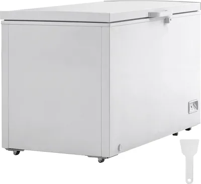 A white chest freezer is shown from a side angle against a white background. A small white scraper tool is visible in the bottom right corner.