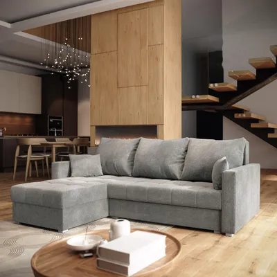 A modern living room with a sectional sofa, coffee table, and staircase.