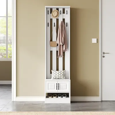 A white entryway organizer with hooks, a cabinet, and a shelf for shoes, set against a light beige wall and a gray floor.