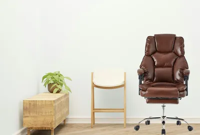 A brown office chair is shown in a room with a wooden cabinet and a stool.
