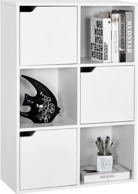 A white cube storage unit with three doors, displaying decorative items and books.