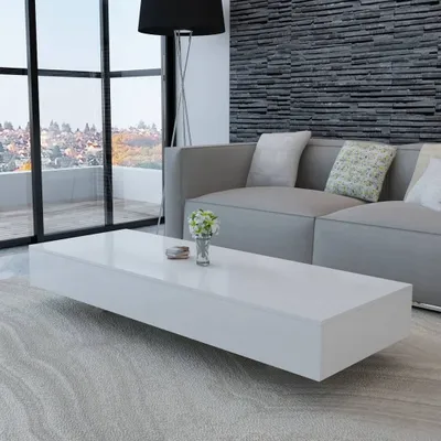 A modern living room with a grey sofa, a black floor lamp, and a white coffee table.
