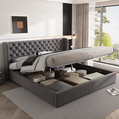 A bedroom scene with a bed with its storage compartments open.