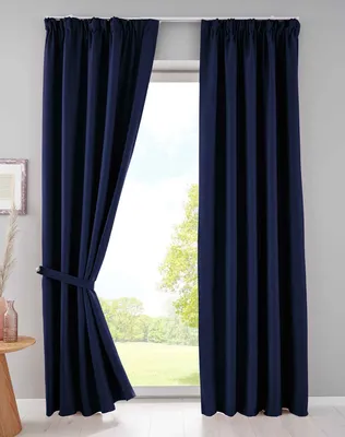 A pair of navy blue curtains are shown tied back on the left side, revealing a window with a view of trees and sky. The curtains are hung from a white rod.
