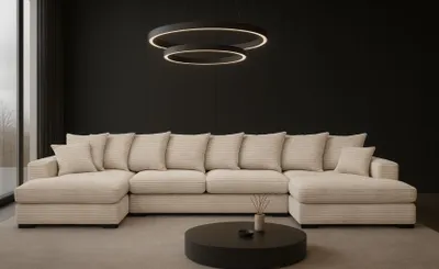 A modern living room with a large U-shaped sectional sofa and a circular coffee table.