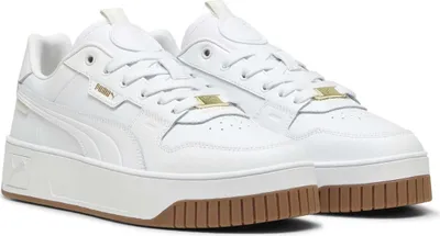 A pair of white Puma sneakers with a gum sole and gold accents.
