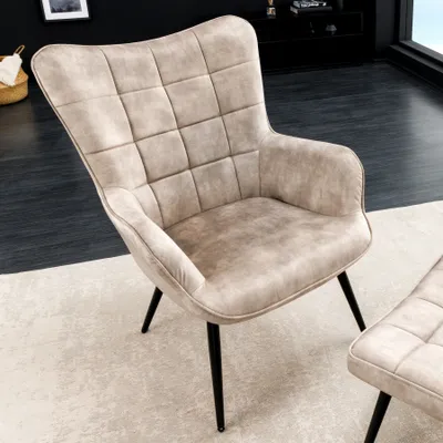 A modern armchair and ottoman in a living room setting.