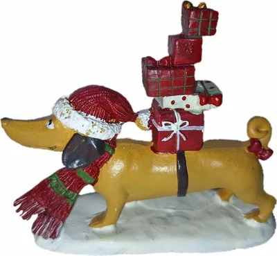 A Christmas-themed dachshund figurine carrying gifts on its back, standing on a snowy base.