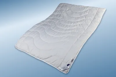 A white duvet is laid out on a gradient blue and white background.