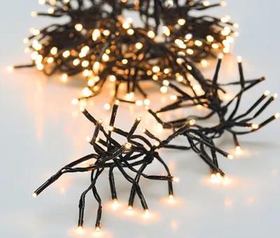 A close-up shot of a string of warm white LED lights on a white background.