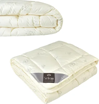 A folded cream-colored duvet with a subtle pattern of sheep and clouds, featuring a grey label with the brand name.
