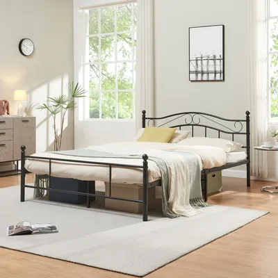 A bedroom scene with a metal bed frame, bedding, and decor.