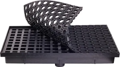 A black drainage mat system with a flexible mat partially lifted to reveal the grid structure underneath.