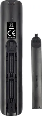 The back of a black remote control with the battery compartment open, showing two AA batteries and the battery cover next to it.