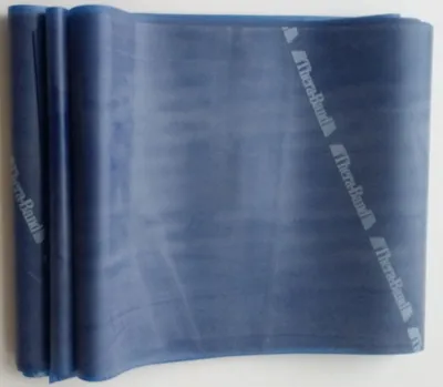 A blue Thera-Band exercise band is rolled up and lying on a white surface.