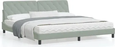 A bed frame with a mattress and bedding, shown from a side angle on a white background.