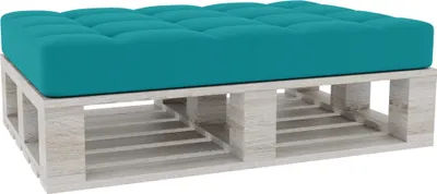 A tufted teal cushion on a white wooden pallet base.