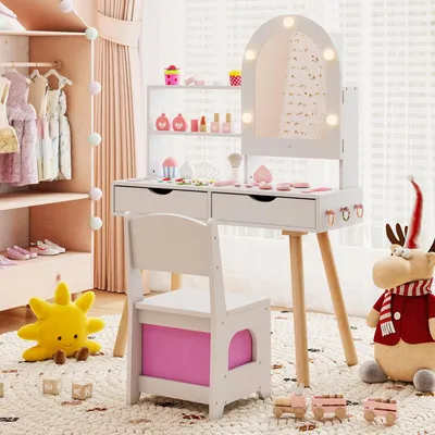 A child's play vanity set with a mirror, chair, and accessories, set up in a bedroom or play area.