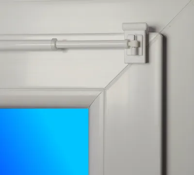 Close-up of a white adjustable curtain rod with a mounting bracket attached to a white frame.