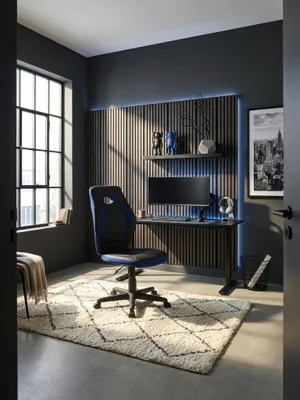 Der schwarz-blaue Kinderschreibtischstuhl aus Kunstleder und Mesh steht einsatzbereit an einem mattschwarzen Metallschreibtisch im modernen Jugendzimmer mit Betonwänden._#sku_SAFSPM1.388#