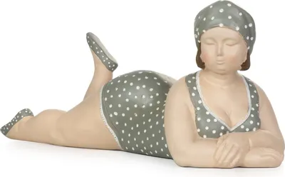 A decorative figurine of a plus-size woman in a polka dot swimsuit, lying down.