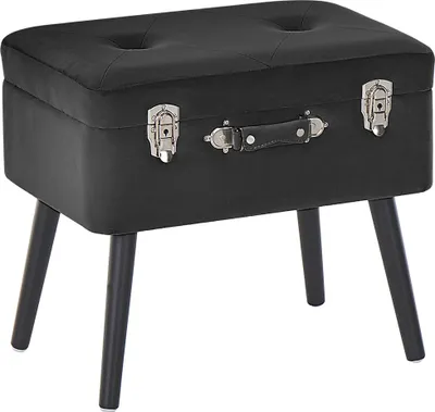 A black velvet ottoman designed to look like a vintage suitcase, with four dark wooden legs.