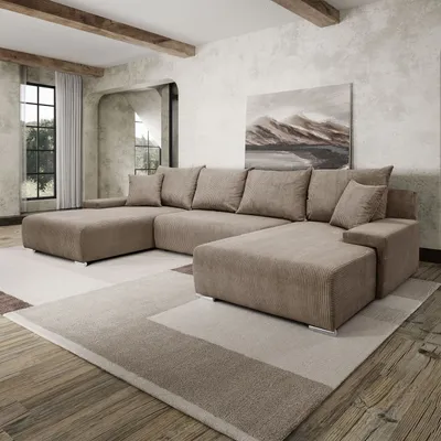 A modern living room with a large sectional sofa, rug, and artwork.