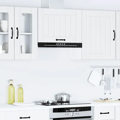 A clean, modern kitchen scene featuring white upper cabinets, a black range hood, and a stovetop with cookware.