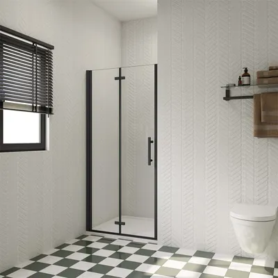 A modern bathroom with a shower door, toilet, and checkered floor.