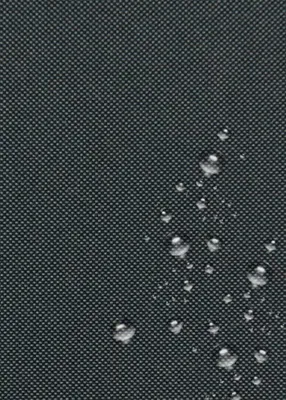 A close-up view of a dark, textured surface with water droplets scattered across it.