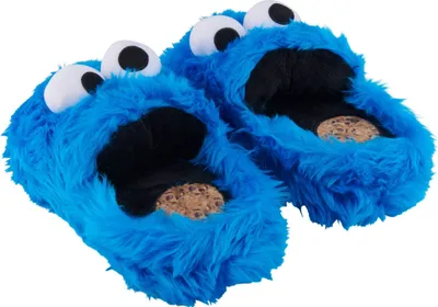 A pair of blue plush slippers shaped like the Cookie Monster from Sesame Street, with cookies visible inside the mouth.