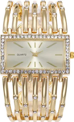 A close-up studio shot of a women's gold-tone watch with a rectangular face and a crystal-embellished band.