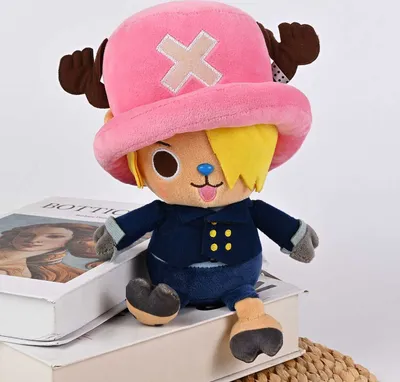A plush toy of the character Chopper from One Piece, sitting on top of books.
