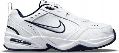A white Nike Air Monarch IV shoe with navy accents, shown from the side.