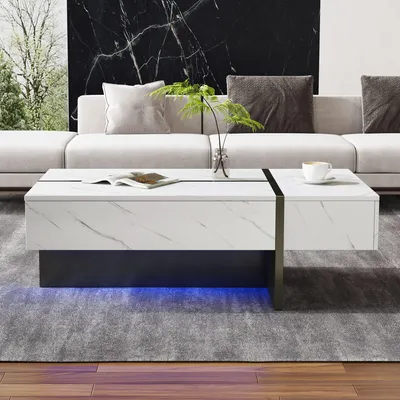 Imagen del producto de Mesa de centro de 105 x 60 x 35 cm, fabricada con tablero de partículas al 100%, color blanco, con 3 cajones, iluminación LED y superficie de alta brillantez con diseño de mármol