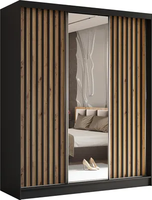 A modern wardrobe with sliding doors, one of which is a mirror, reflecting a bedroom interior with a bed and pillows.