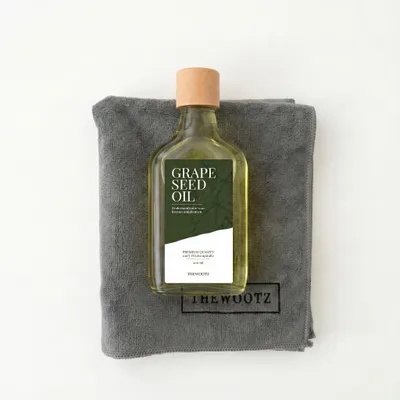 TheWootz starterspakket 200 ml: fles druivenpitolie op een grijze microvezeldoek