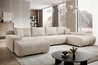 A modern living room with a large U-shaped sectional sofa, coffee table, and large windows.