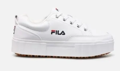 A white Fila sneaker with a platform sole is shown against a white background.