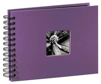 A purple spiral-bound photo album with a square window on the cover displaying a black and white close-up of a plant bud.