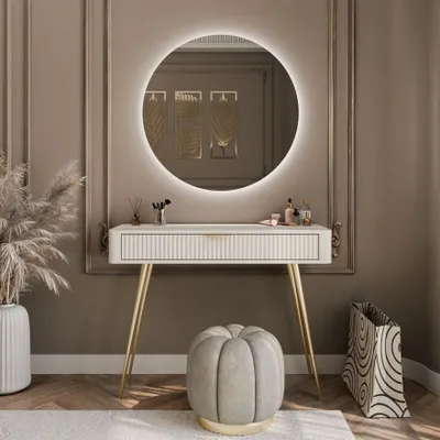 A vanity table with a round LED mirror, a stool, and decorative items in a room.
