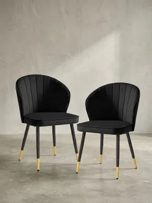 Frontale Ansicht des eleganten Esszimmerstuhls aus tiefschwarzem Samt mit 83 cm Höhe und filigranen schwarzen Metallbeinen mit edlen Goldkappen._#sku_SAFWL6.951#