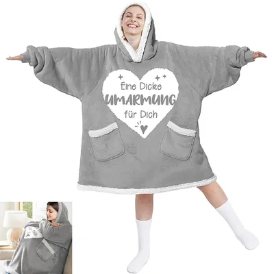 A woman wearing a gray oversized hoodie blanket with white trim and a heart graphic with text.