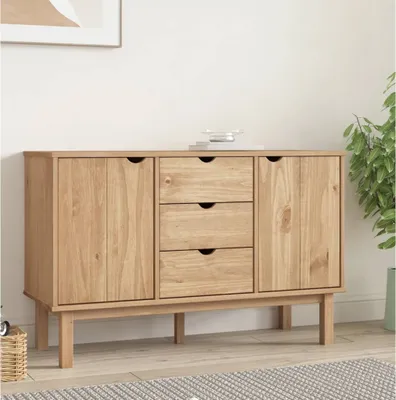 A wooden sideboard with drawers and doors, placed in a room setting with a plant and a framed picture on the wall.