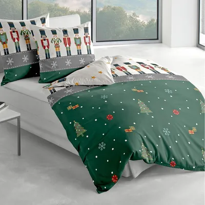 A bed with Christmas-themed bedding featuring nutcrackers and festive patterns.