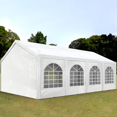A white party tent set up on a grassy lawn with trees in the background.