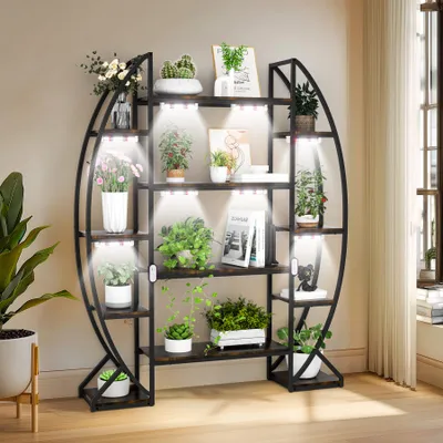A multi-tiered plant stand with integrated grow lights, filled with various potted plants.