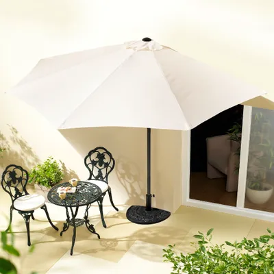 An outdoor patio set with a table, two chairs, and a large white umbrella.
