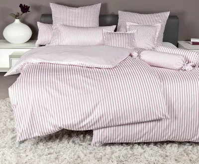 A neatly made bed with striped bedding.