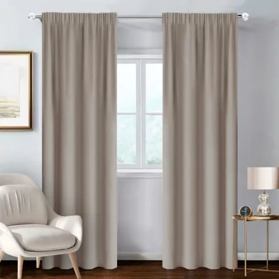 A room interior with curtains, a chair, and a side table with a lamp.